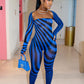 Woman in a blue and black striped outfit by Gsuwoo standing in a hallway.