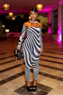 Woman in a zebra-striped outfit  by Gsuwoo standing in a stylishly decorated room with pink lighting.