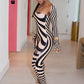 Woman in a zebra-striped outfit by Gsuwoo standing in a hallway with a bench and colorful wall art.