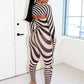 Model wearing a black and nude striped outfit by Gsuwoo in a minimal white room.